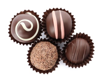 Many different delicious chocolate truffles on white background, top view