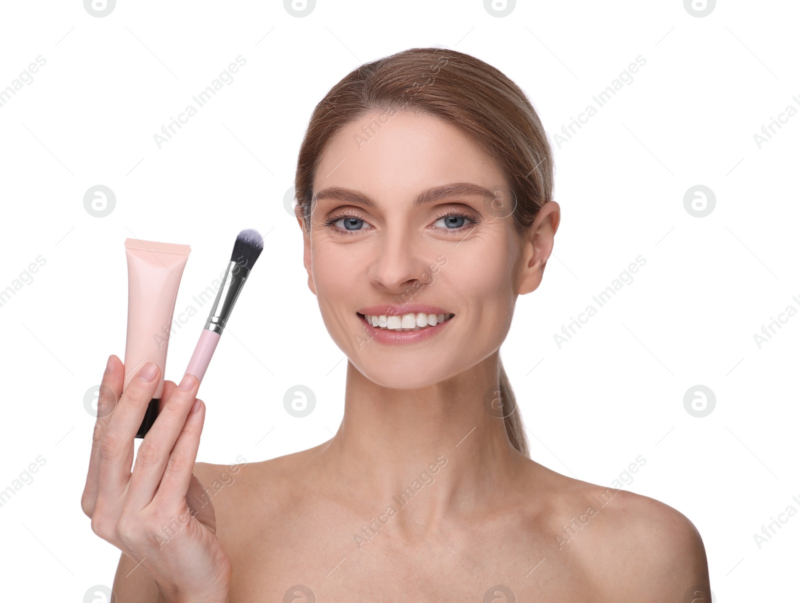 Photo of Woman holding makeup brush and tube of foundation on white background