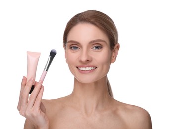 Photo of Woman holding makeup brush and tube of foundation on white background