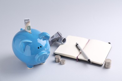 Financial savings. Piggy bank, dollar banknotes, coins and stationery on grey background