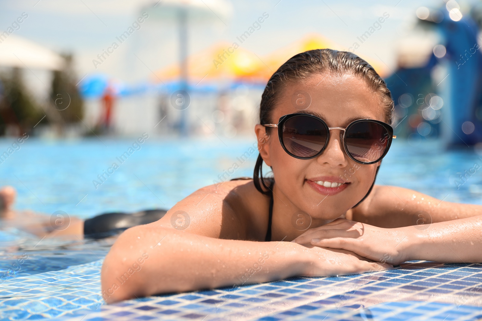 Photo of Young woman in outdoor swimming pool. Summer vacation