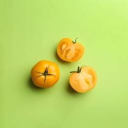 Photo of Yellow tomatoes on green background, flat lay