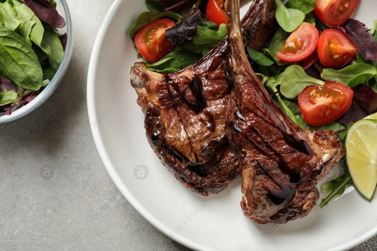 Photo of Delicious grilled ribs served on light grey table, flat lay