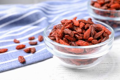 Photo of Dried goji berries on white wooden table, closeup