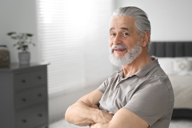 Photo of Portrait of handsome senior man at home, space for text