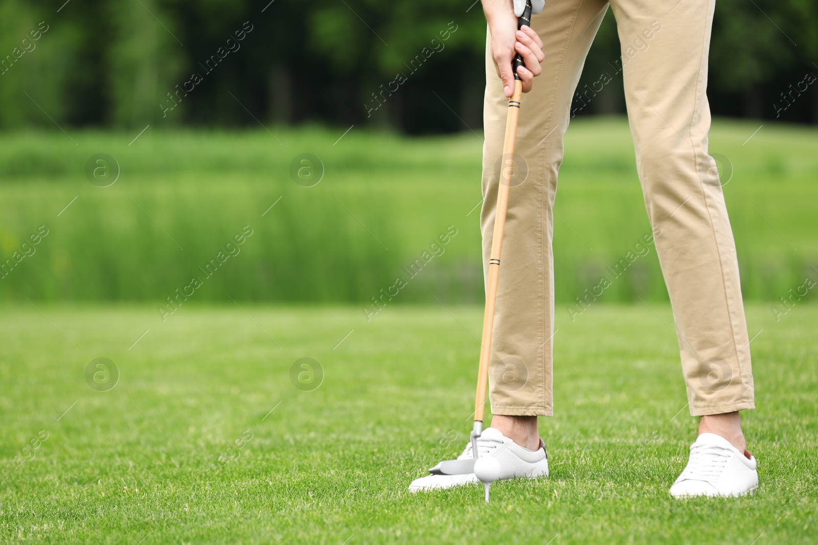 Photo of Man playing golf on green course. Sport and leisure