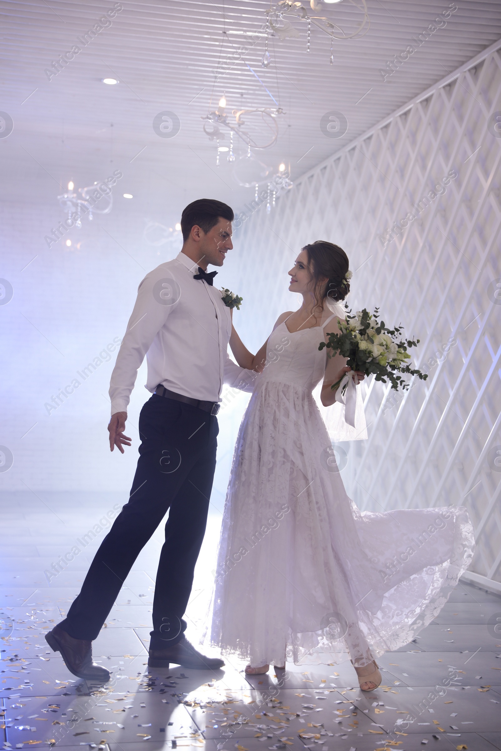 Photo of Happy newlywed couple dancing together in festive hall