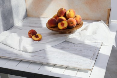 Photo of Stand with juicy peaches and double-sided backdrops in photo studio