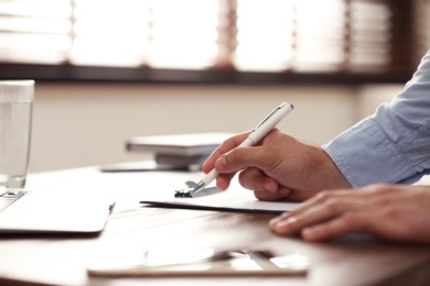 Photo of Business trainer working at table in office, closeup