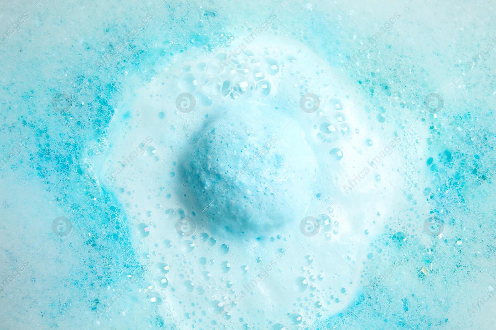 Photo of Color bath bomb dissolving in water, top view