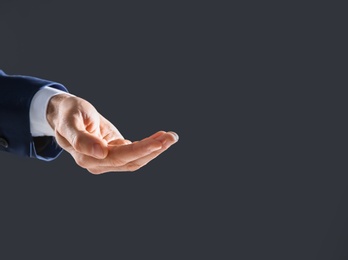 Businessman holding something in hand on dark background