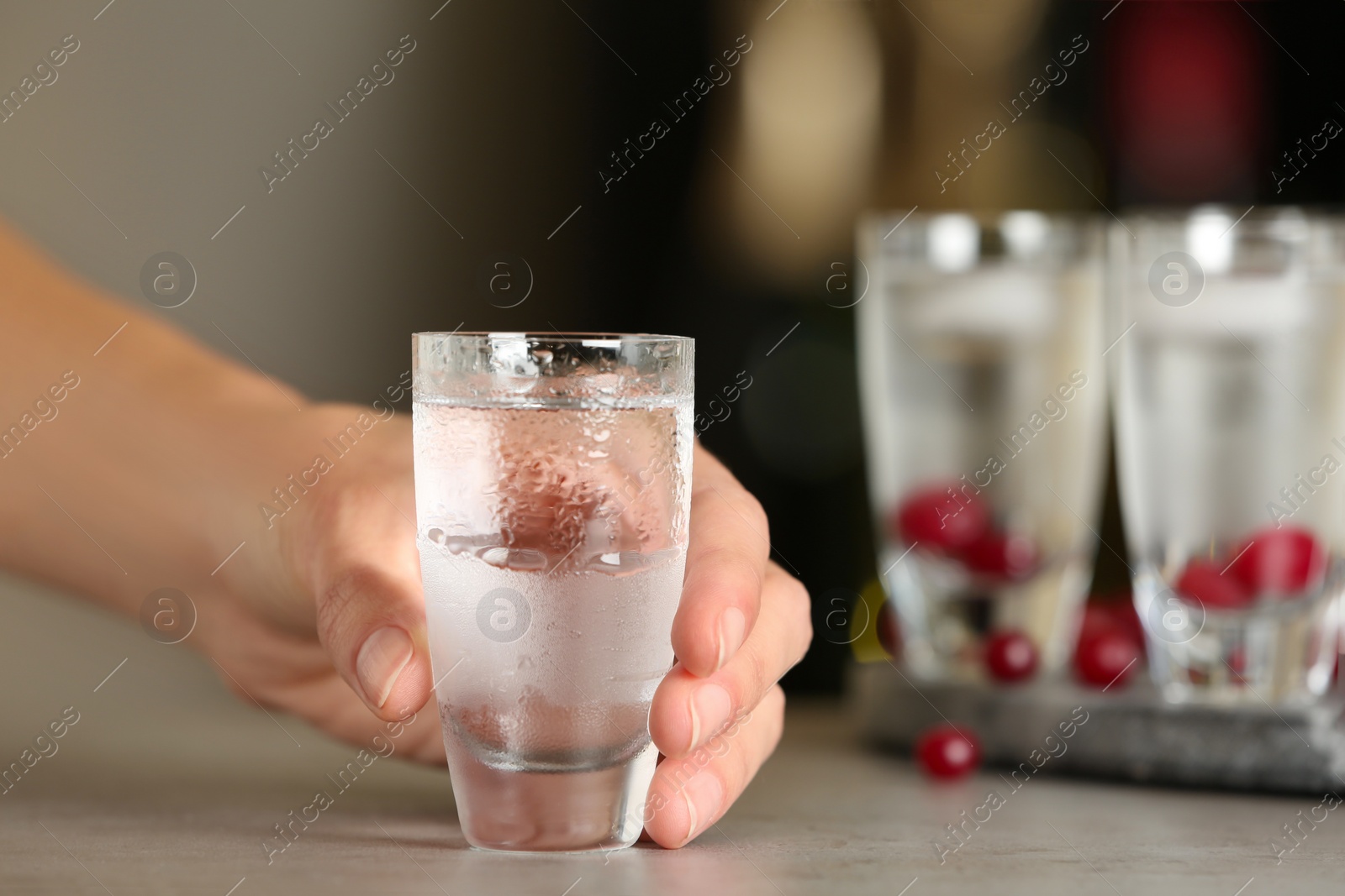 Photo of Woman with shot of vodka at table in bar, closeup