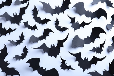 Many black paper bats on white background, flat lay. Halloween decor