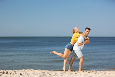 Photo of Happy young couple having fun at beach on sunny day