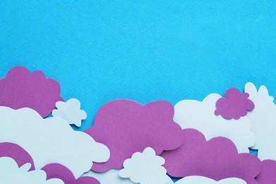 Photo of Paper speech bubbles in shape of clouds on light blue background, flat lay. Space for text