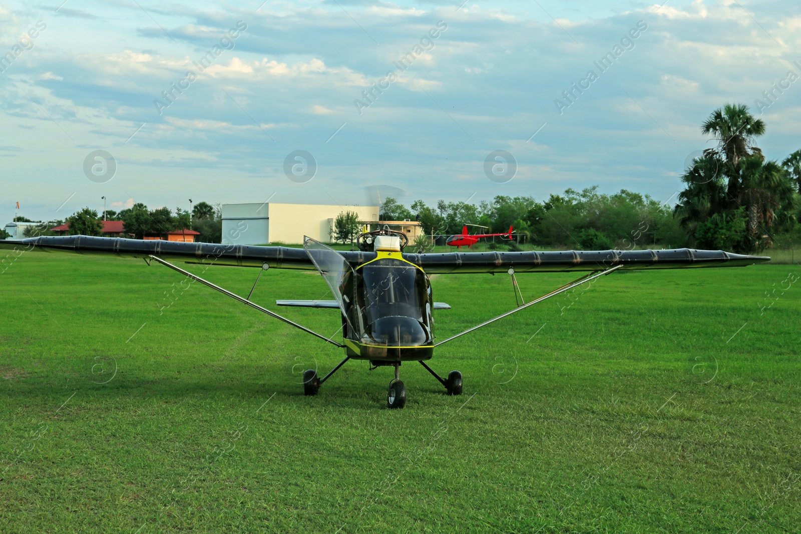 Photo of Modern colorful airplane on green grass outdoors