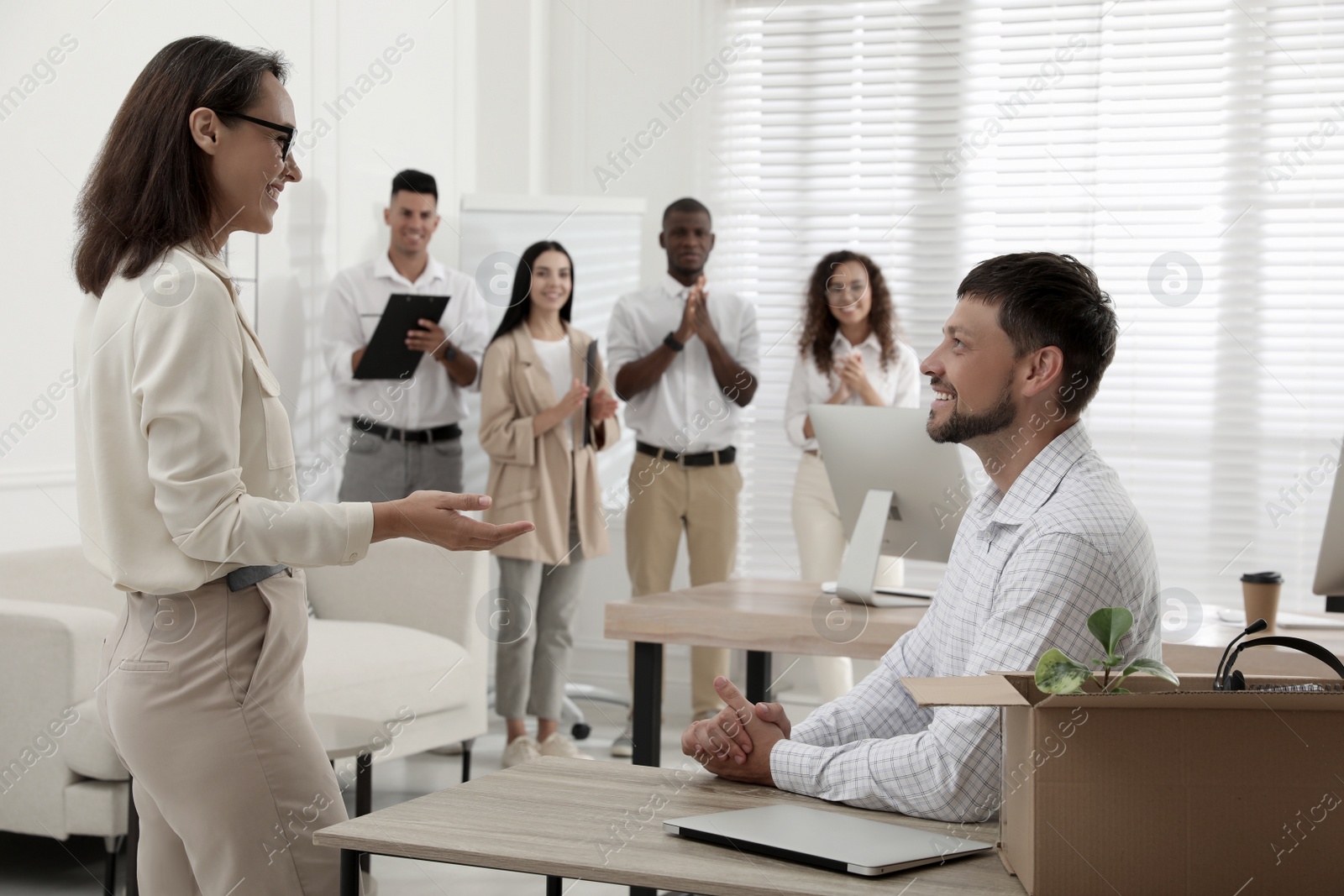 Photo of Boss introducing new employee to coworkers in office