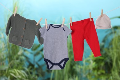 Photo of Baby clothes drying on laundry line outdoors