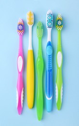 Photo of Many different toothbrushes on light blue background, flat lay