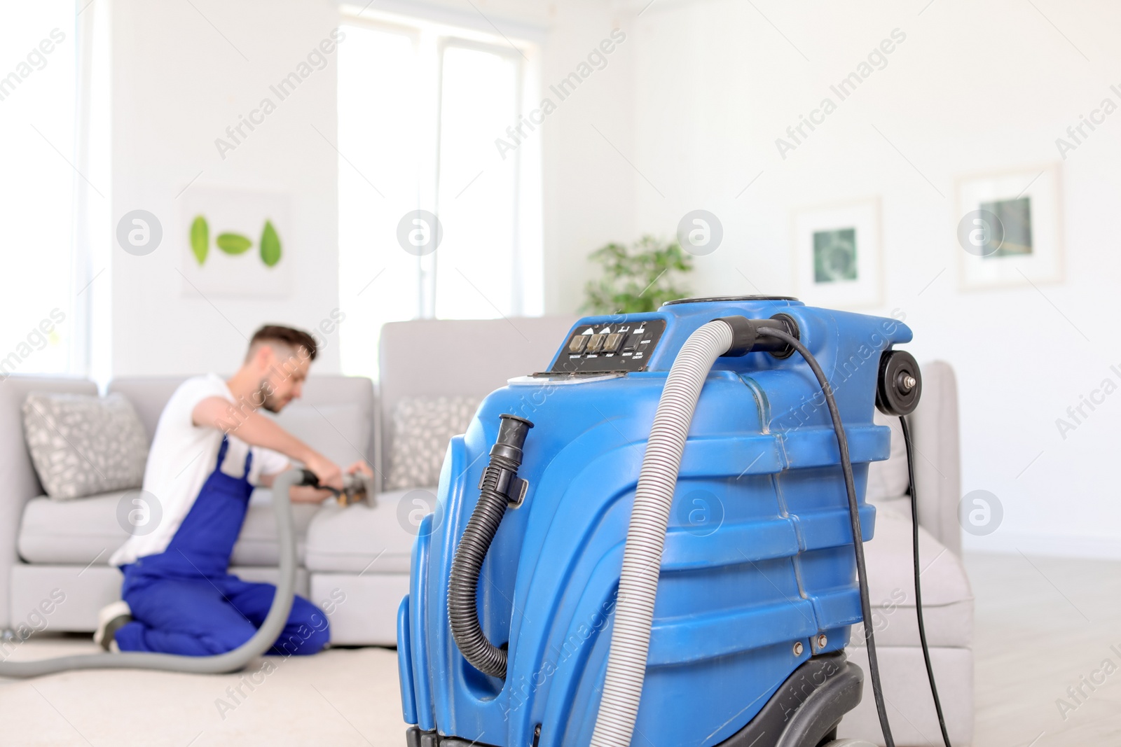 Photo of Dry cleaning machine and male worker on background