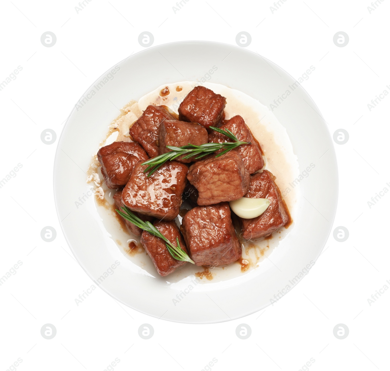 Photo of Plate with delicious cooked beef, garlic and rosemary isolated on white, top view. Tasty goulash