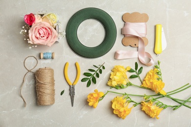 Florist equipment with flowers on light background, top view