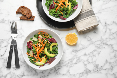 Tasty fresh kale salad on marble table, flat lay