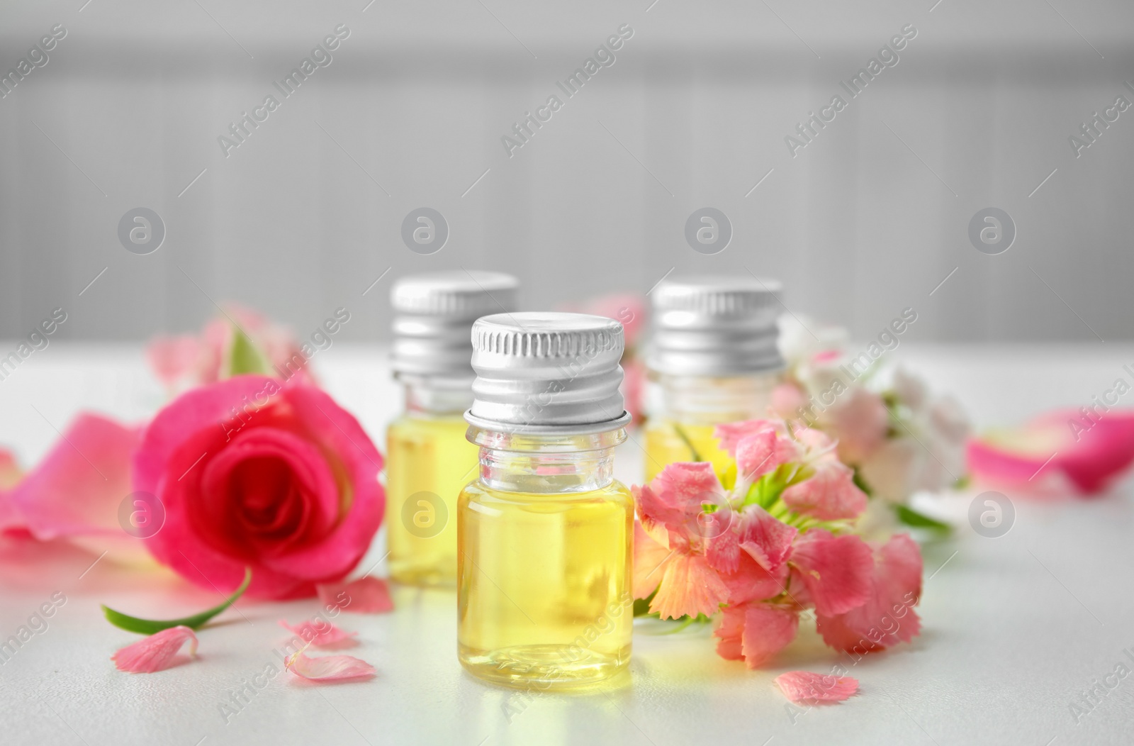 Photo of Composition with essential oils and flowers on table