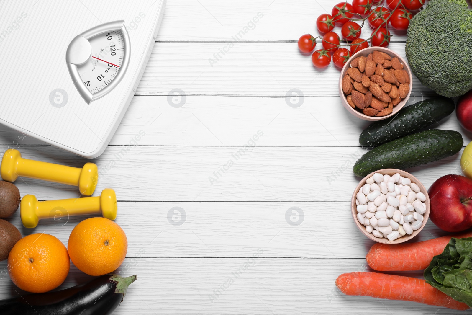 Photo of Scales, dumbbells, fresh fruits and vegetables on white wooden table, flat lay with space for text. Low glycemic index diet