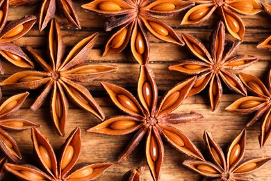 Aromatic anise stars on wooden table, flat lay