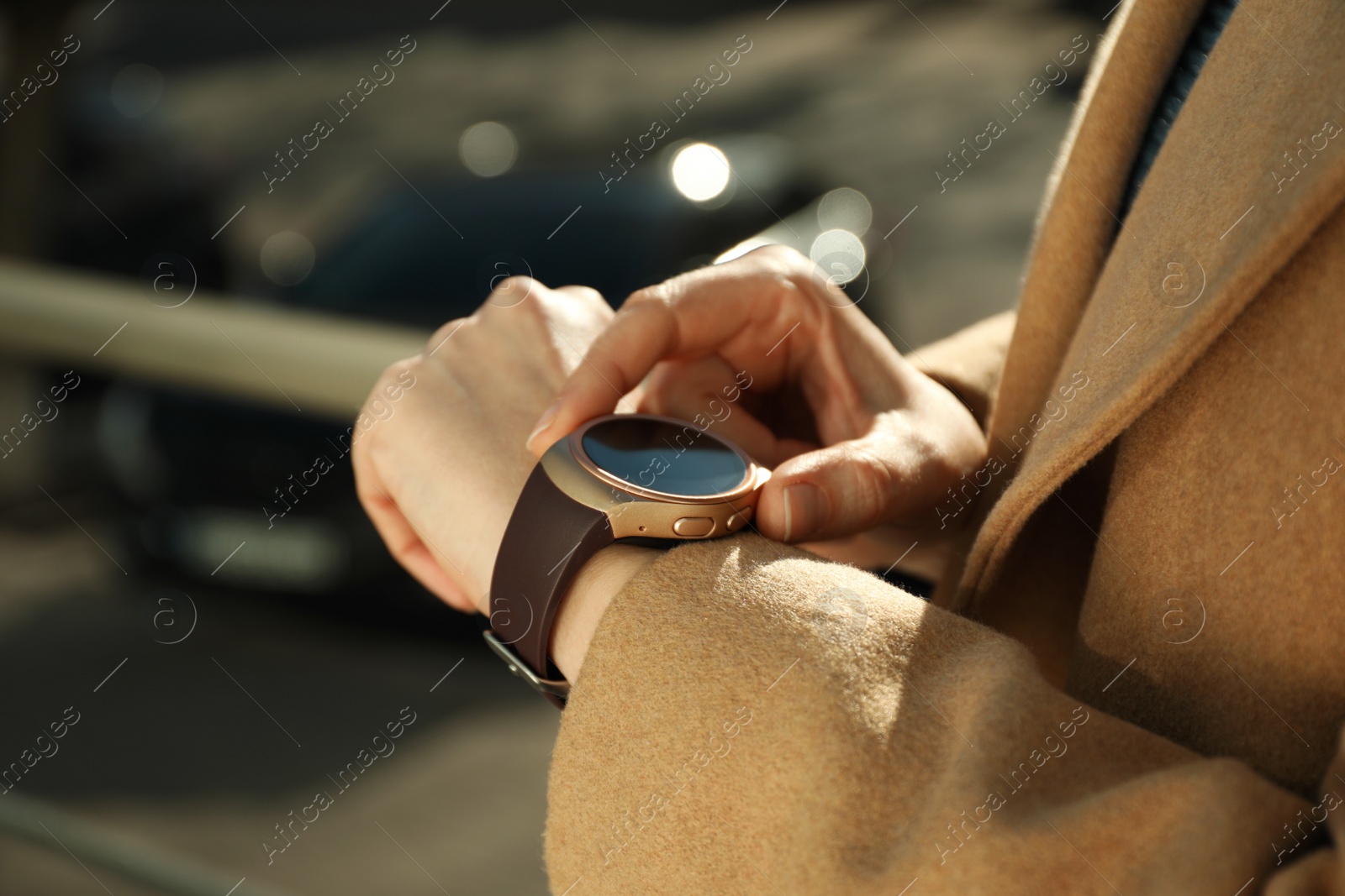 Photo of Mature woman using smart watch outdoors, closeup