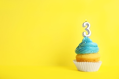 Photo of Birthday cupcake with number three candle on yellow background, space for text