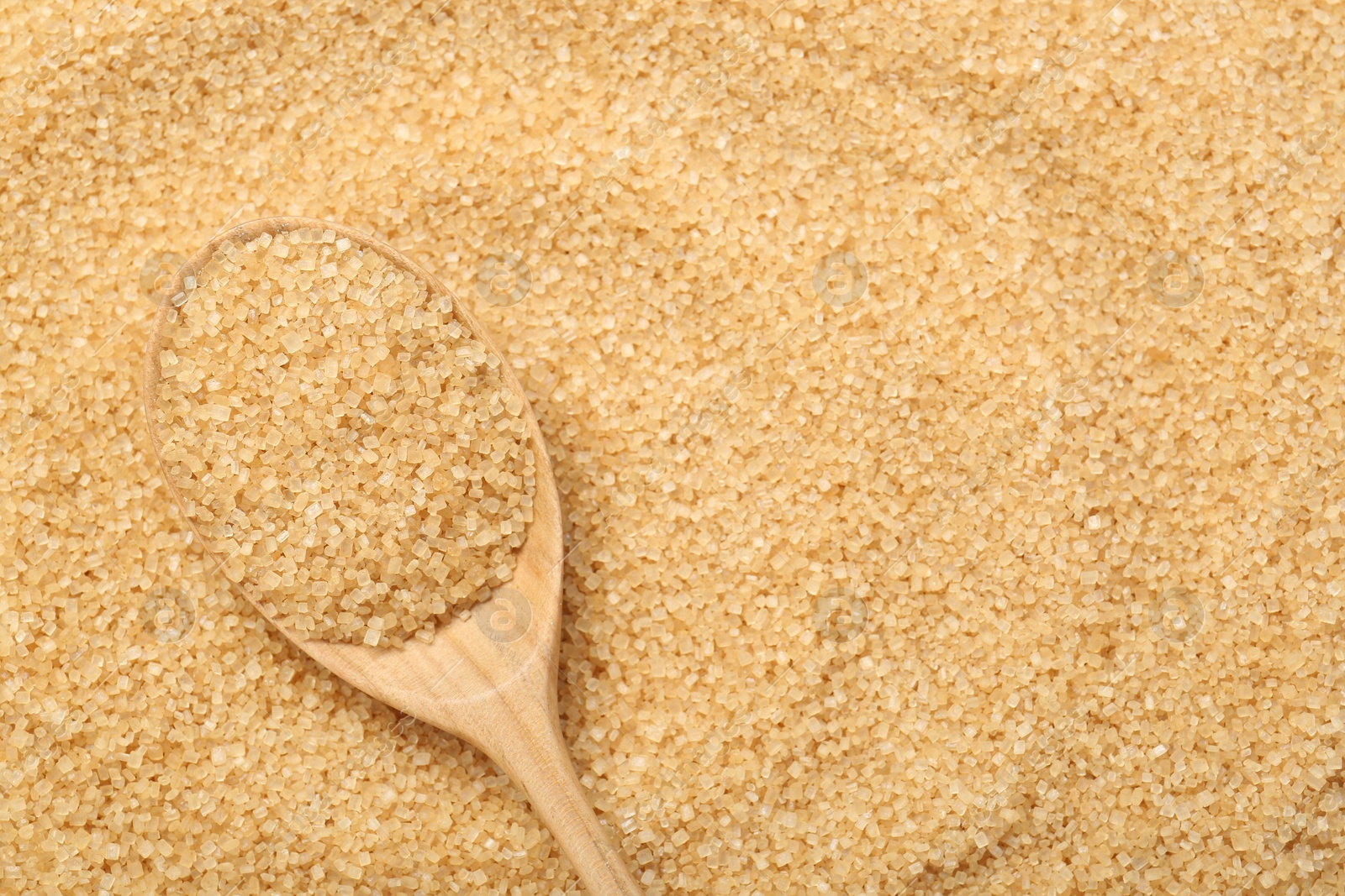 Photo of Spoon on granulated brown sugar, top view