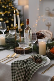 Christmas table setting with festive decor and dishware in room