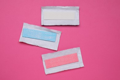 Photo of Unwrapped sticks of tasty chewing gum on bright pink background, flat lay