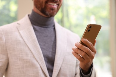 Photo of Man using his smartphone in office, closeup