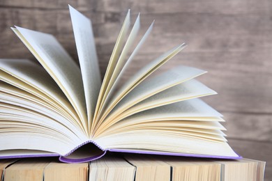 Different books against wooden background, closeup view