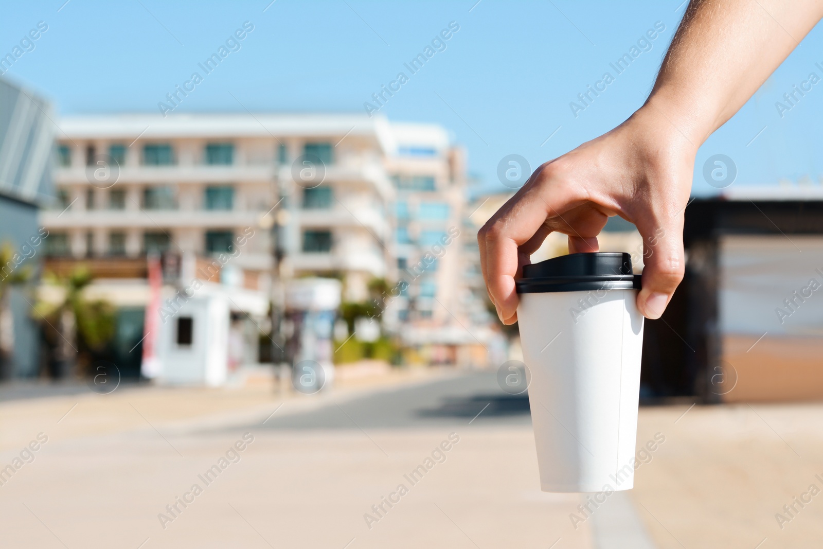 Photo of Woman holding takeaway coffee cup outdoors, closeup. Space for text