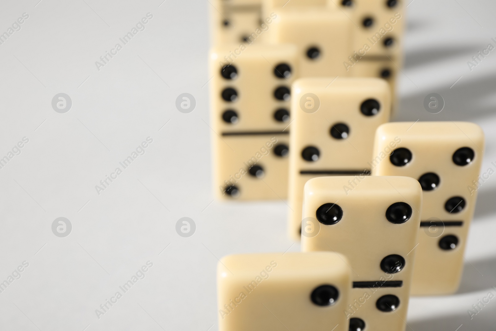 Photo of Domino tiles on white background, closeup. Space for text