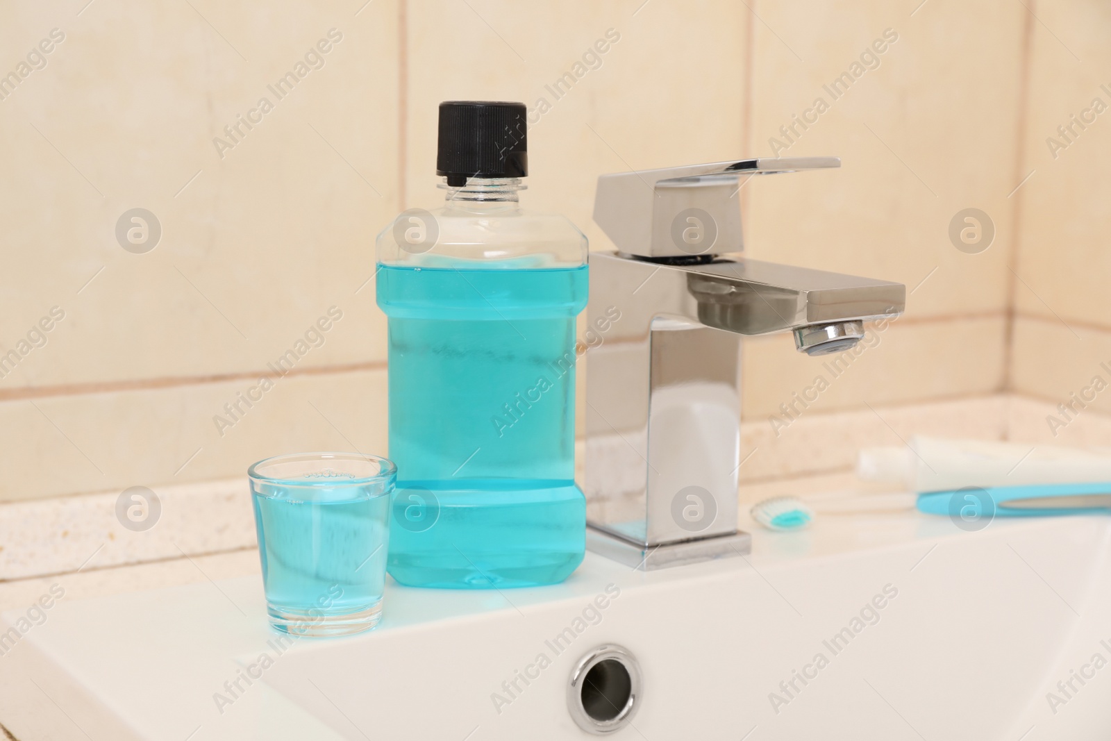 Photo of Mouthwash near tap on sink in bathroom. Teeth and oral care