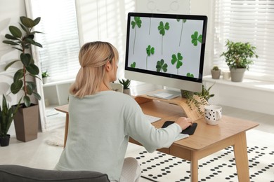 Photo of Woman working at table in light room, back view. Home office