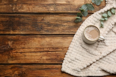 Photo of Flat lay composition with coffee and warm plaid on wooden table, space for text