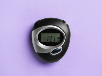 Digital timer on violet background, top view