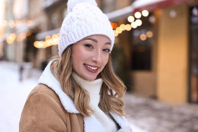 Photo of Portrait of smiling woman on city street in winter. Space for text