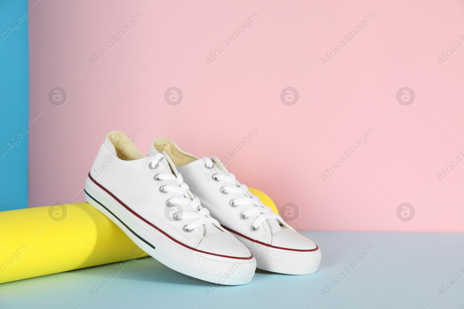 Photo of Pair of stylish sneakers on color background