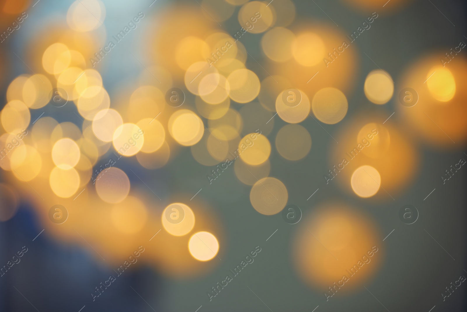 Photo of Blurred view of gold lights on dark background. Bokeh effect