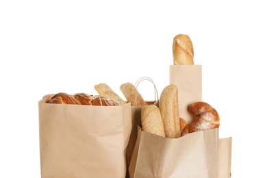 Different fresh bakery products in paper bags on white background