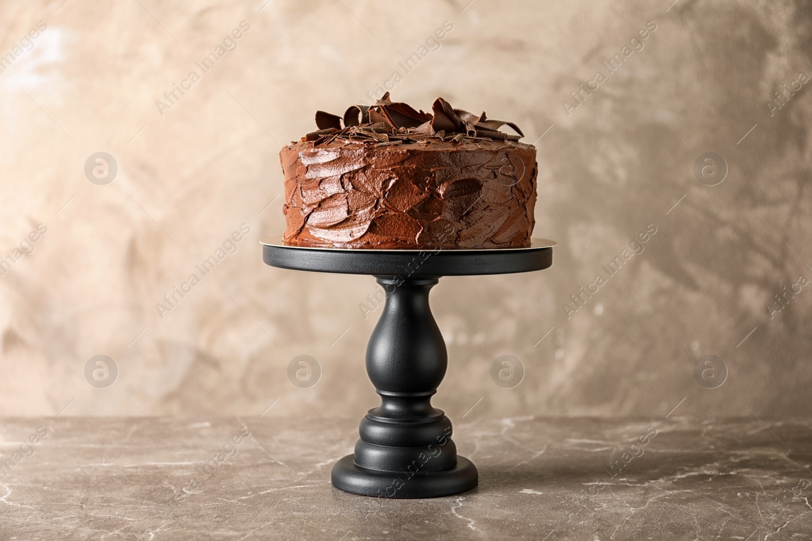 Photo of Stand with tasty homemade chocolate cake on table