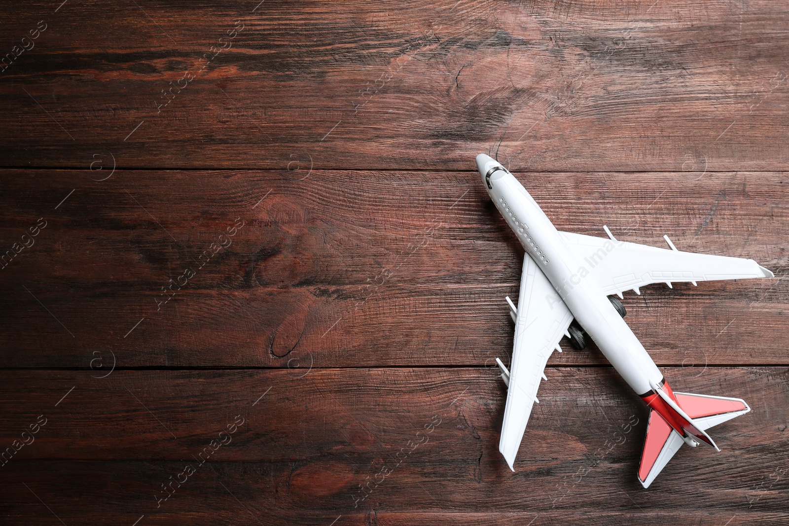 Photo of Toy airplane on wooden background, top view. Space for text