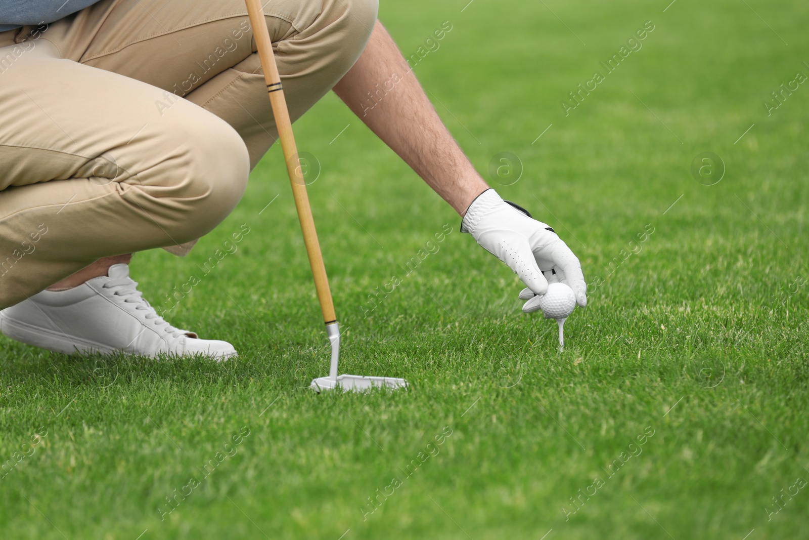 Photo of Man playing golf on green course. Sport and leisure